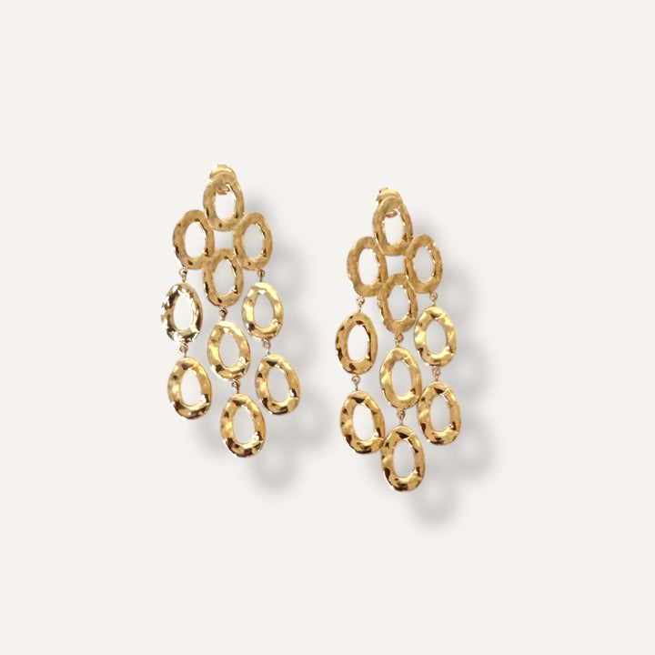 Gold chandelier earrings on a light gray background